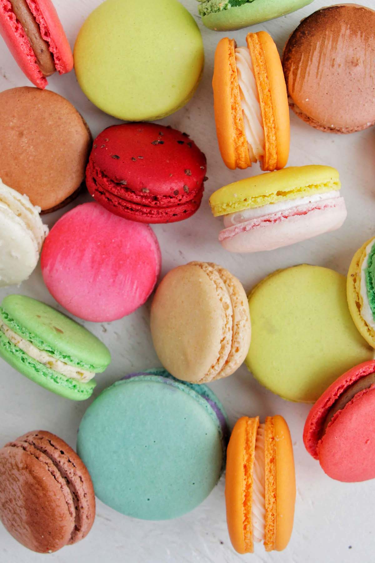 various colored macarons on a white background.