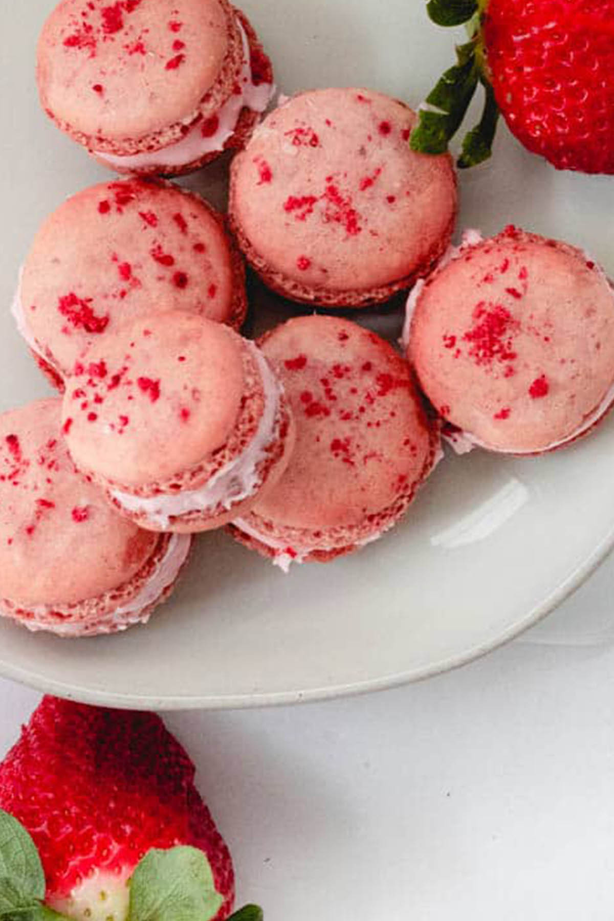 pink macarons topped with freeze dried strawberries.