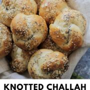 knotted challah rolls in a bowl.