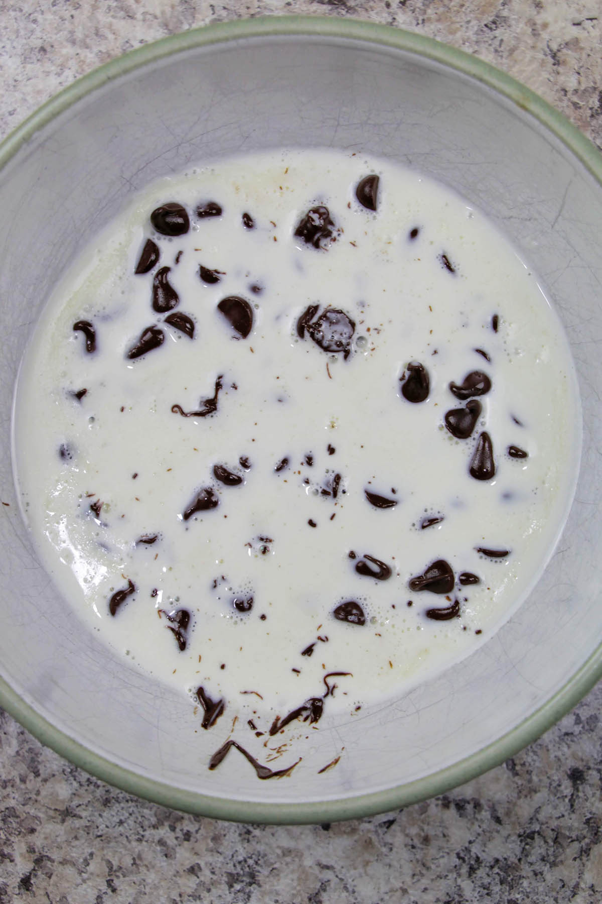 small bowl filled with chocolate chips and heavy cream.