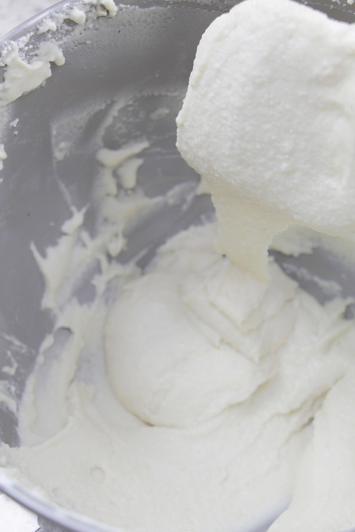 white macaron batter falling off a silicone spatula.