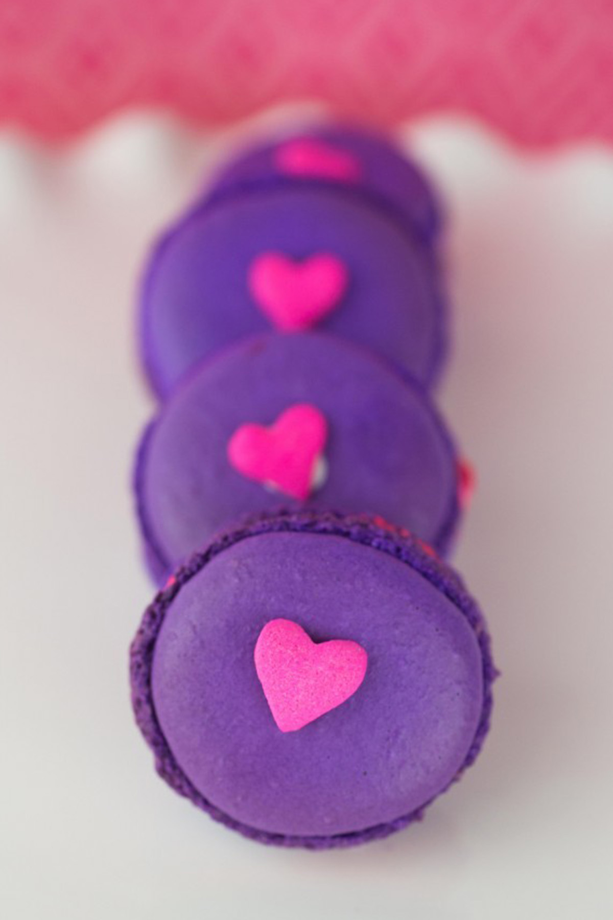 purple macarons with a pink heart sprinkle on top.