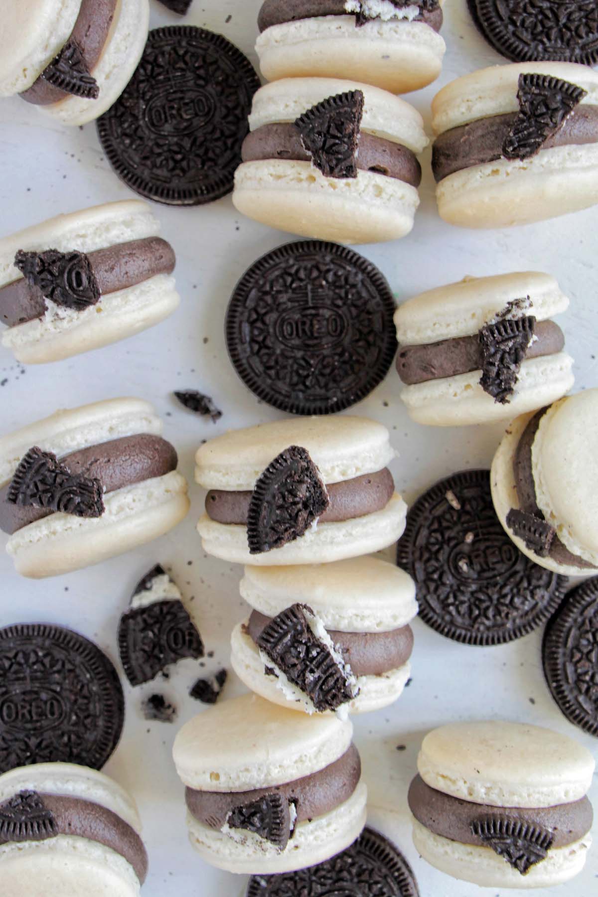 white macaron shells filled with black Oreo buttercream topped with an Oreo cookie piece.