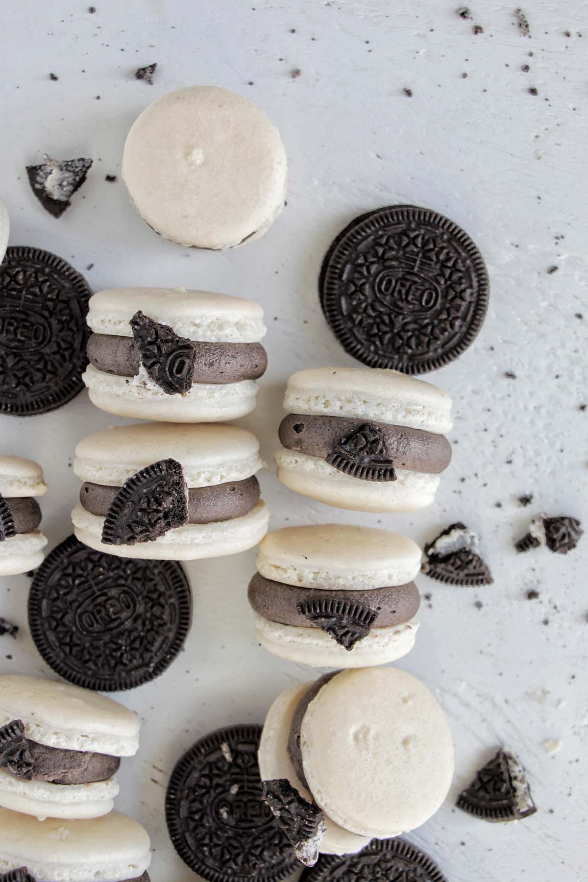 white macaron shells filled with black Oreo buttercream topped with an Oreo cookie piece.