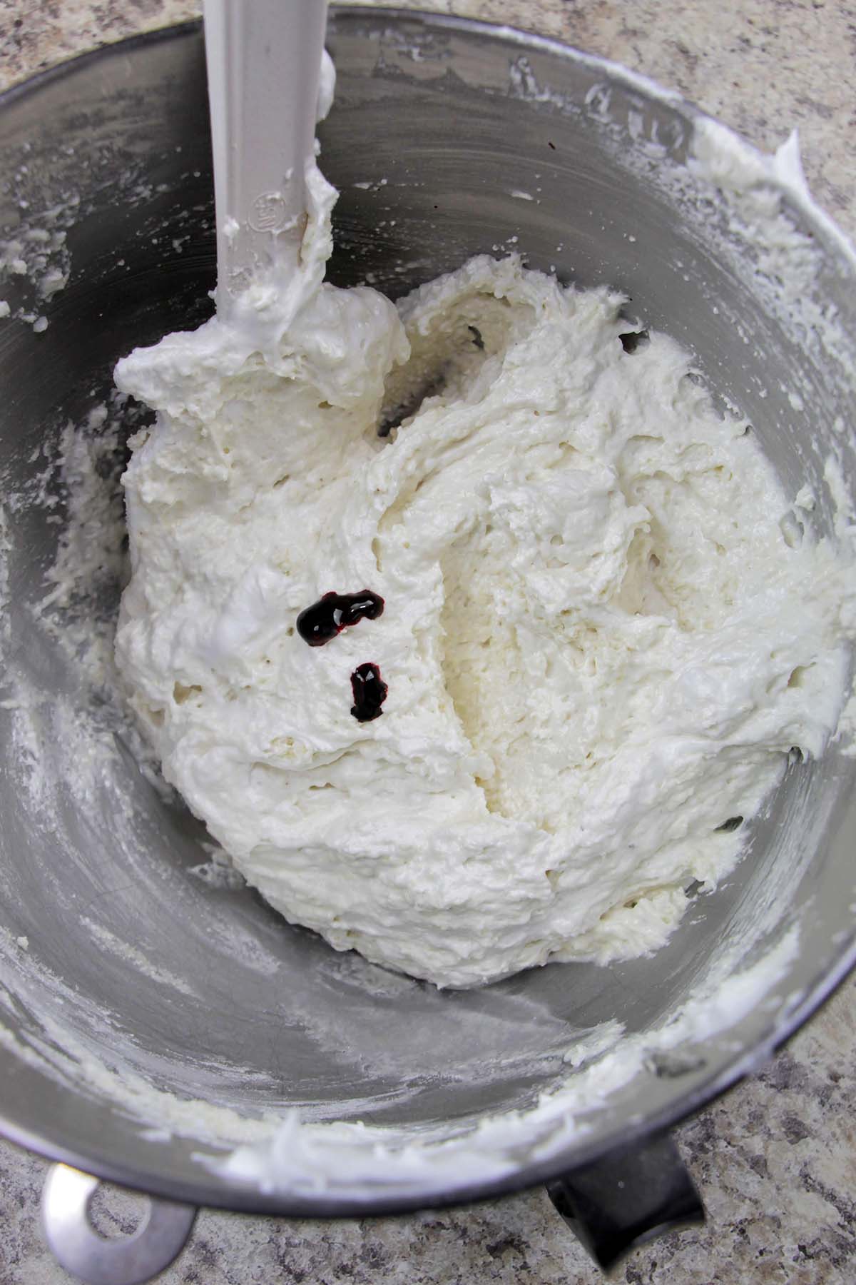 macaron batter with drops of red food coloring.