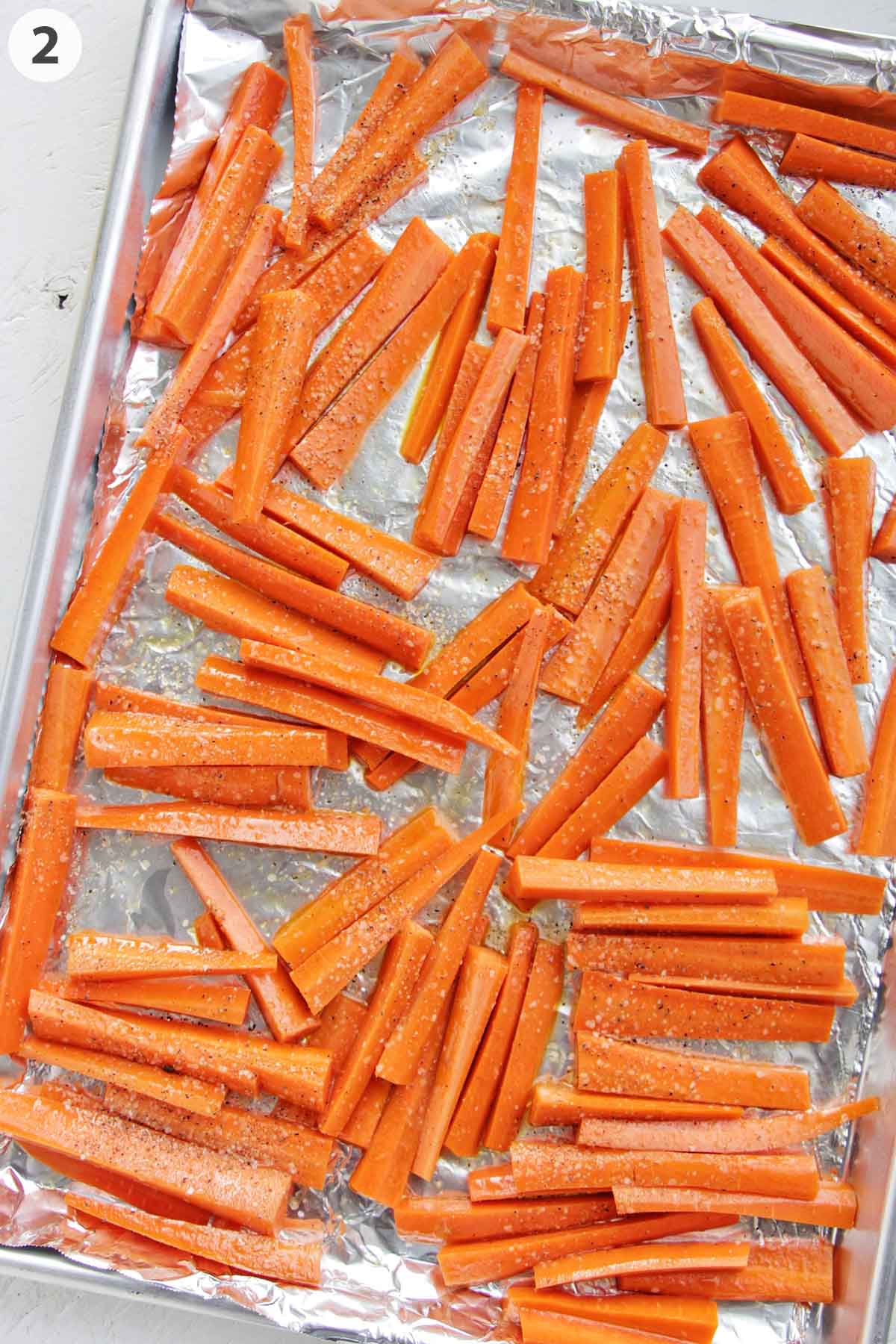 numbered photo showing oil glazed carrots on a sheet pan.