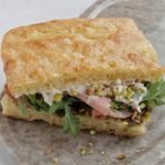 focaccia sandwich with mortadella, burrata, and pistachio.