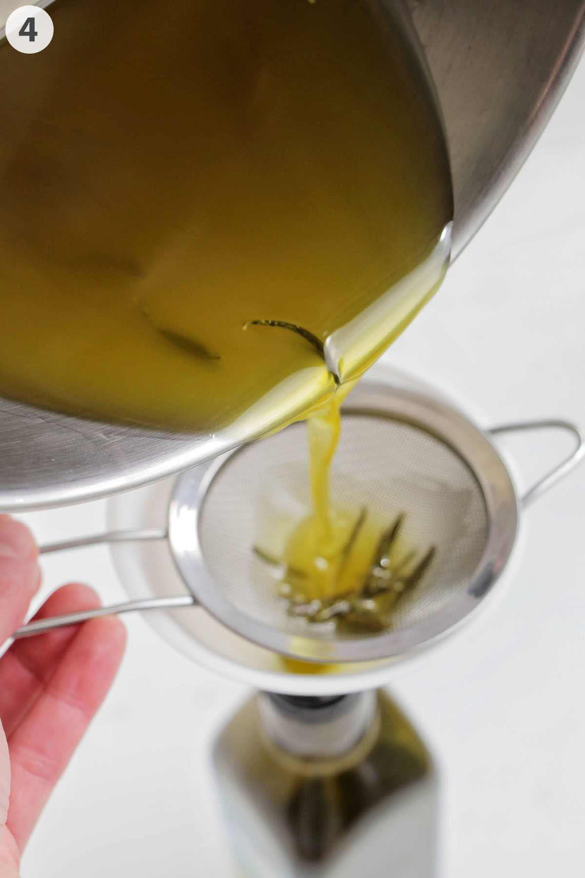 numbered photo straining rosemary olive oil into a bottle.