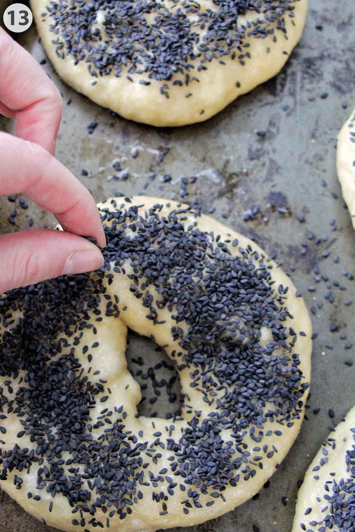 numbered photo adding sesame seeds on top of uncooked bagels.