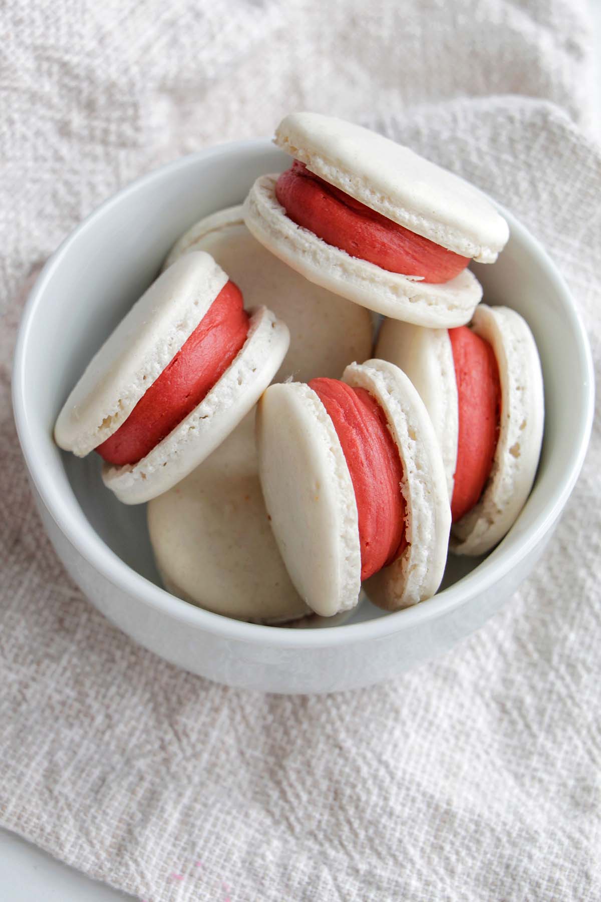 white macarons filled with red velvet filling.