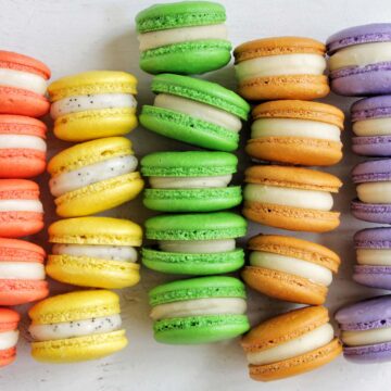 rainbow macaron shells lined up next to each other.