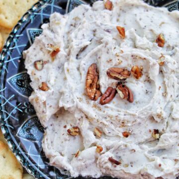 goat cheese and fig dip on a plate next to crackers.