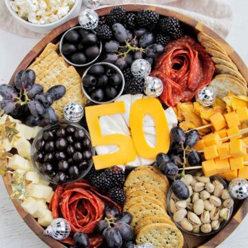 50th birthday gold, white, and black cheese board.