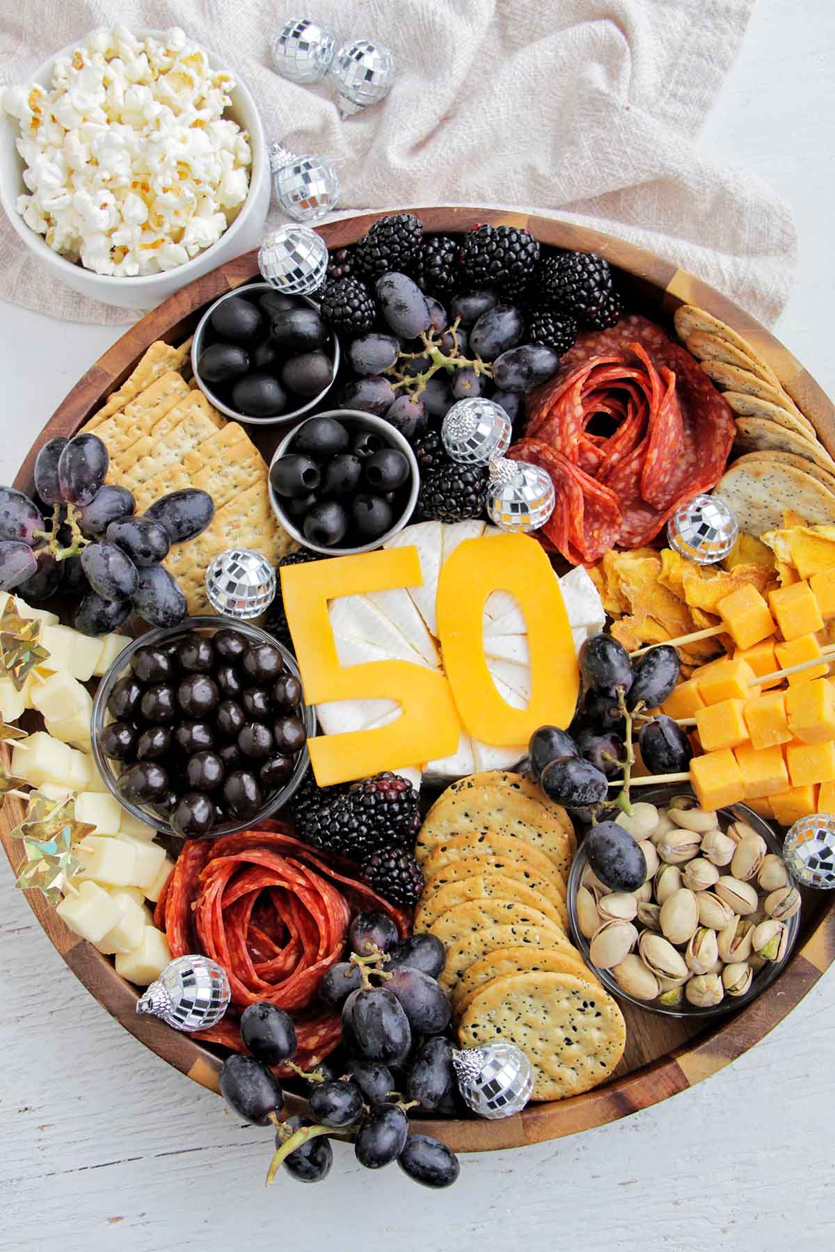 50th birthday gold, white, and black cheese board.