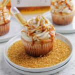 three peanut butter whiskey cupcakes next to Skrewball alcohol bottle.