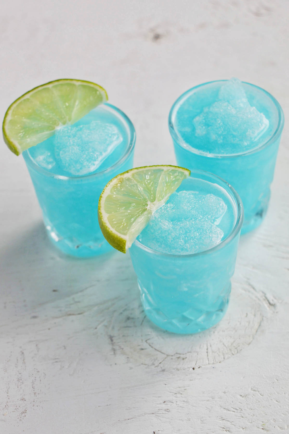 three blue blended margarita shots.