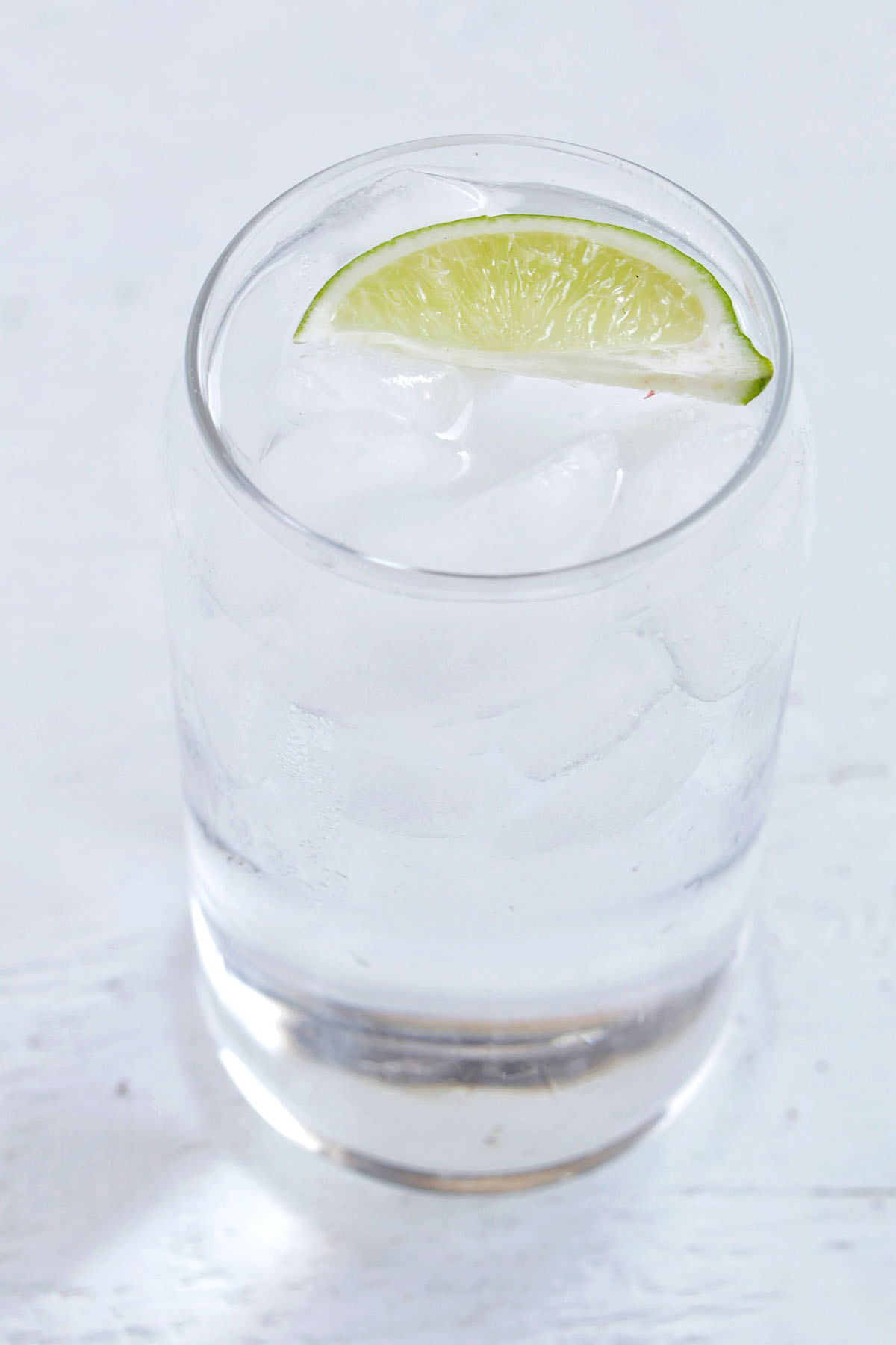 gin soda cocktail with lime garnish.