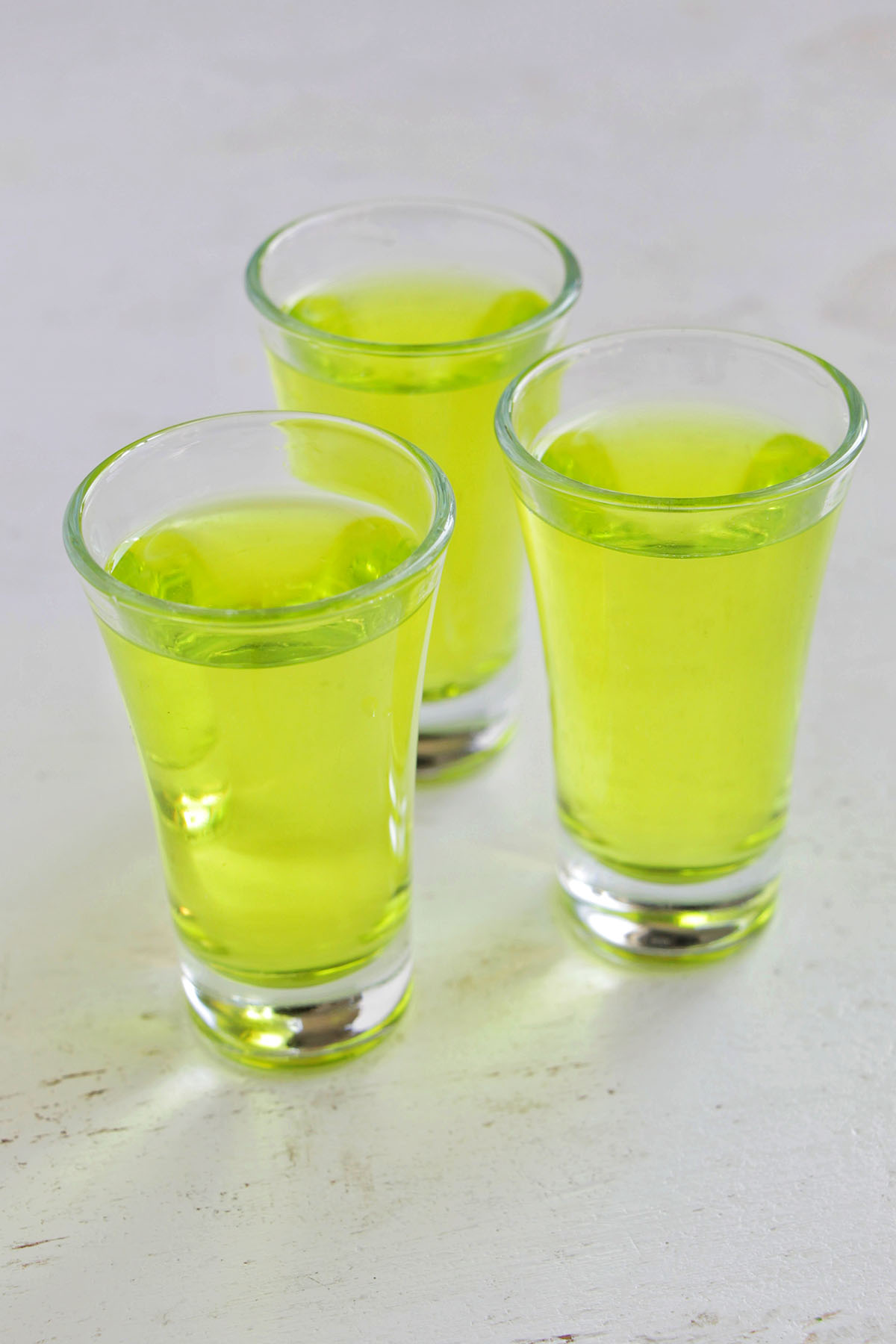 three green honeydew martini shots.