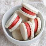 red velvet macarons in a bowl.