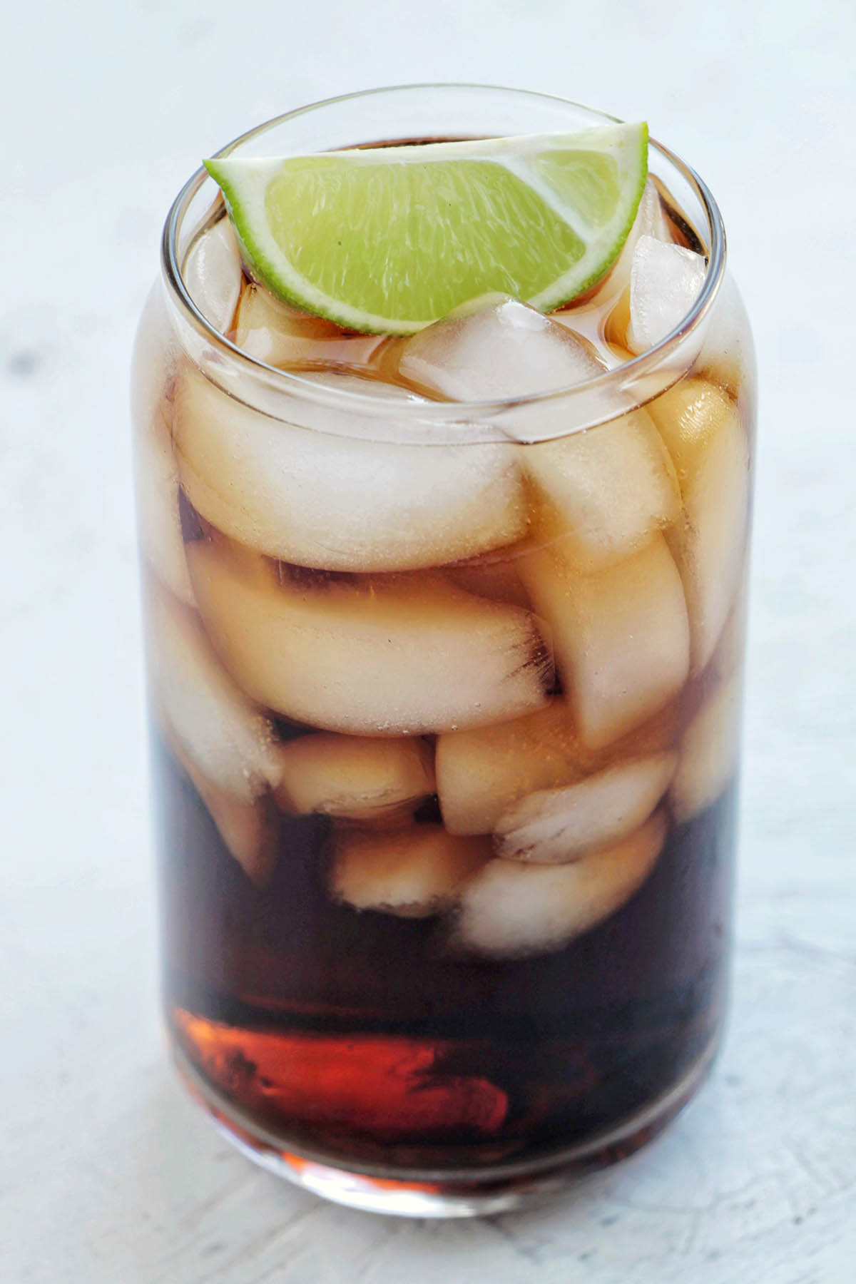 tequila coke with lime garnish.