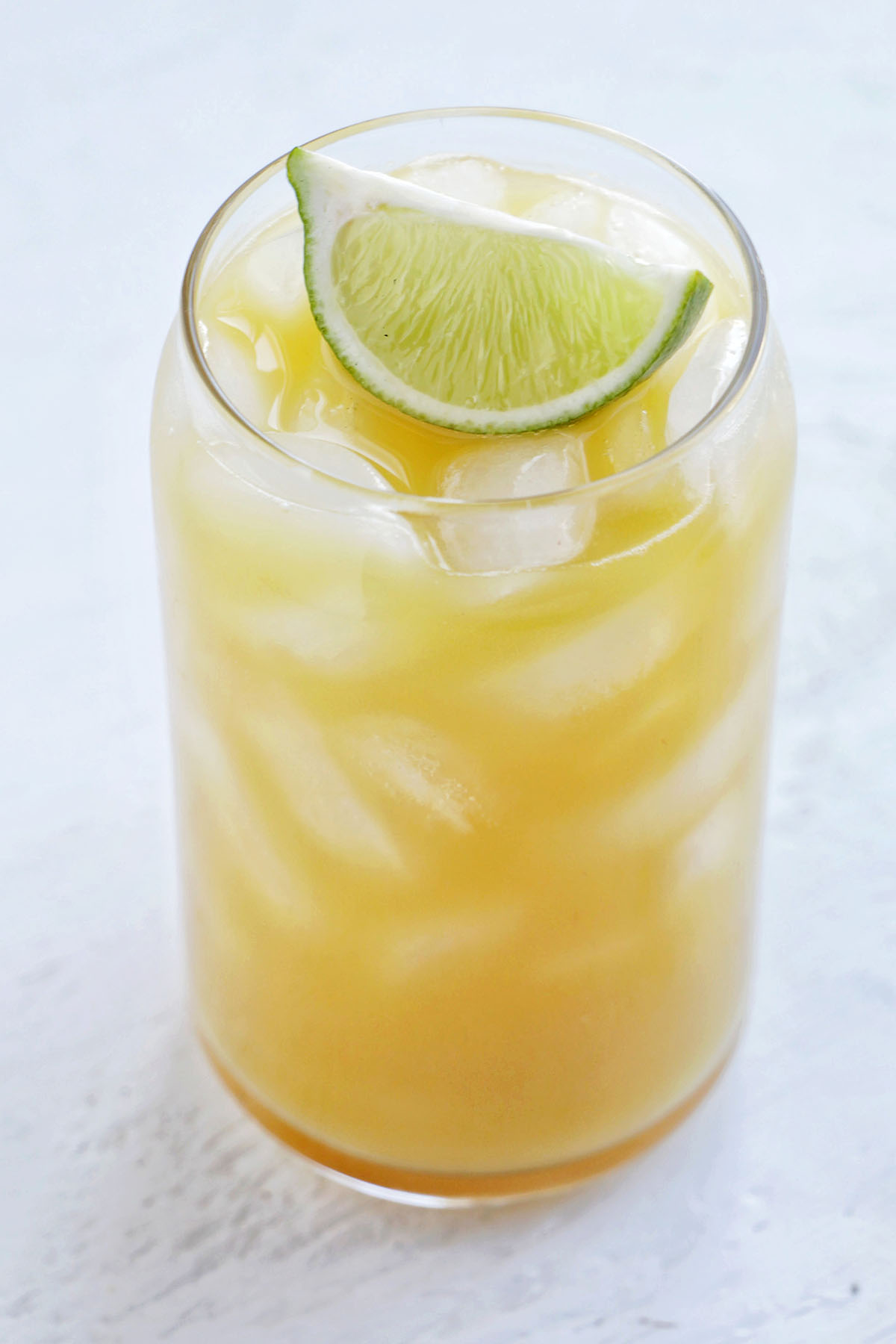 tequila pineapple drink with lime garnish.