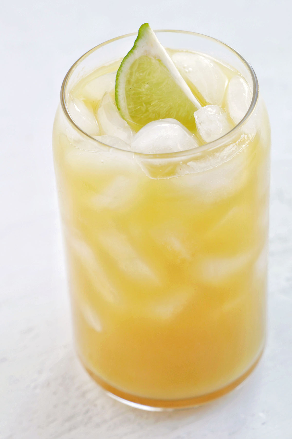 tropical pineapple drink with lime garnish.