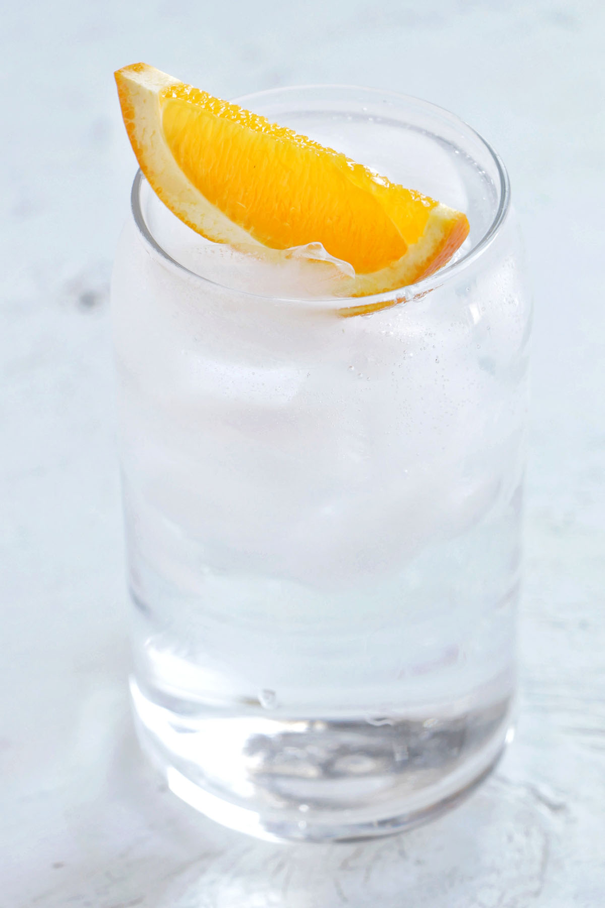 vodka soda with orange garnish.