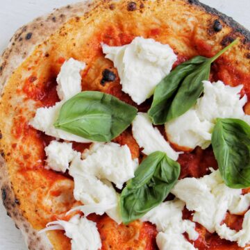 pizza topped with basil and fresh mozzarella.