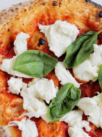pizza topped with basil and fresh mozzarella.