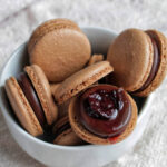 chocolate cherry macarons in a bowl.