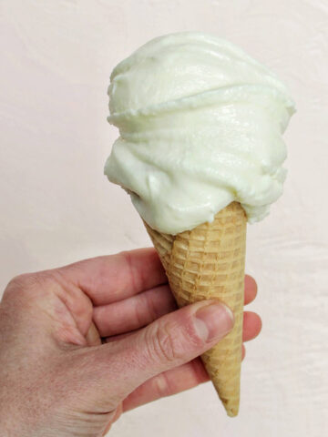 hand holding a cone with fior di latte gelato.