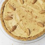 pie plate holding a graham cracker crust and cheesecake filling.