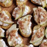 ricotta and apple crostini on a wooden tray.