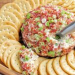 bacon cheddar cheese ball surrounded by crackers.