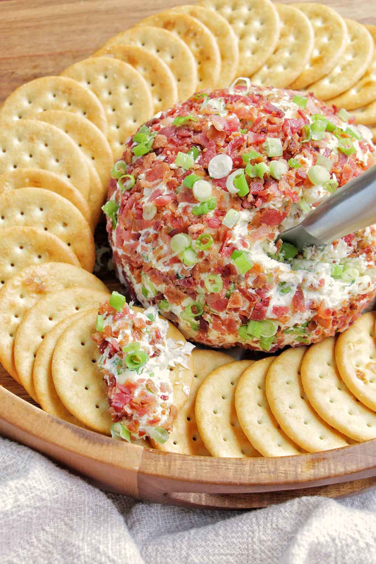 bacon cheddar cheese ball surrounded by crackers.