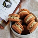 skrewball peanut butter whiskey bottle next to bowl of macarons.