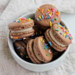 chocolate and yellow cake batter macarons in a bowl.