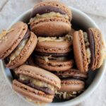 German chocolate cake macarons in a bowl.