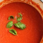 Italian tomato sauce in a pot with basil.