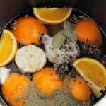 oranges, garlic, and spices in water for wet brine.
