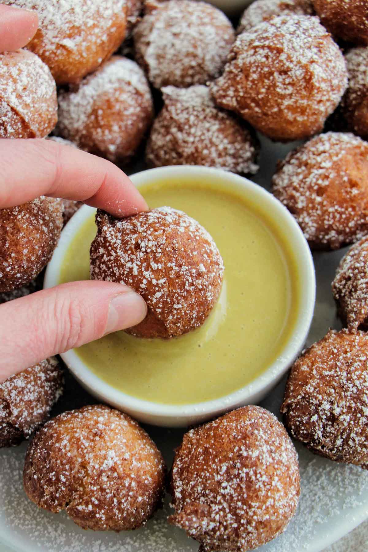 dipping donuts into pistachio crème anglaise sauce.