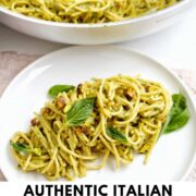 plate of pistachio pesto pasta with basil garnish with text overlay.