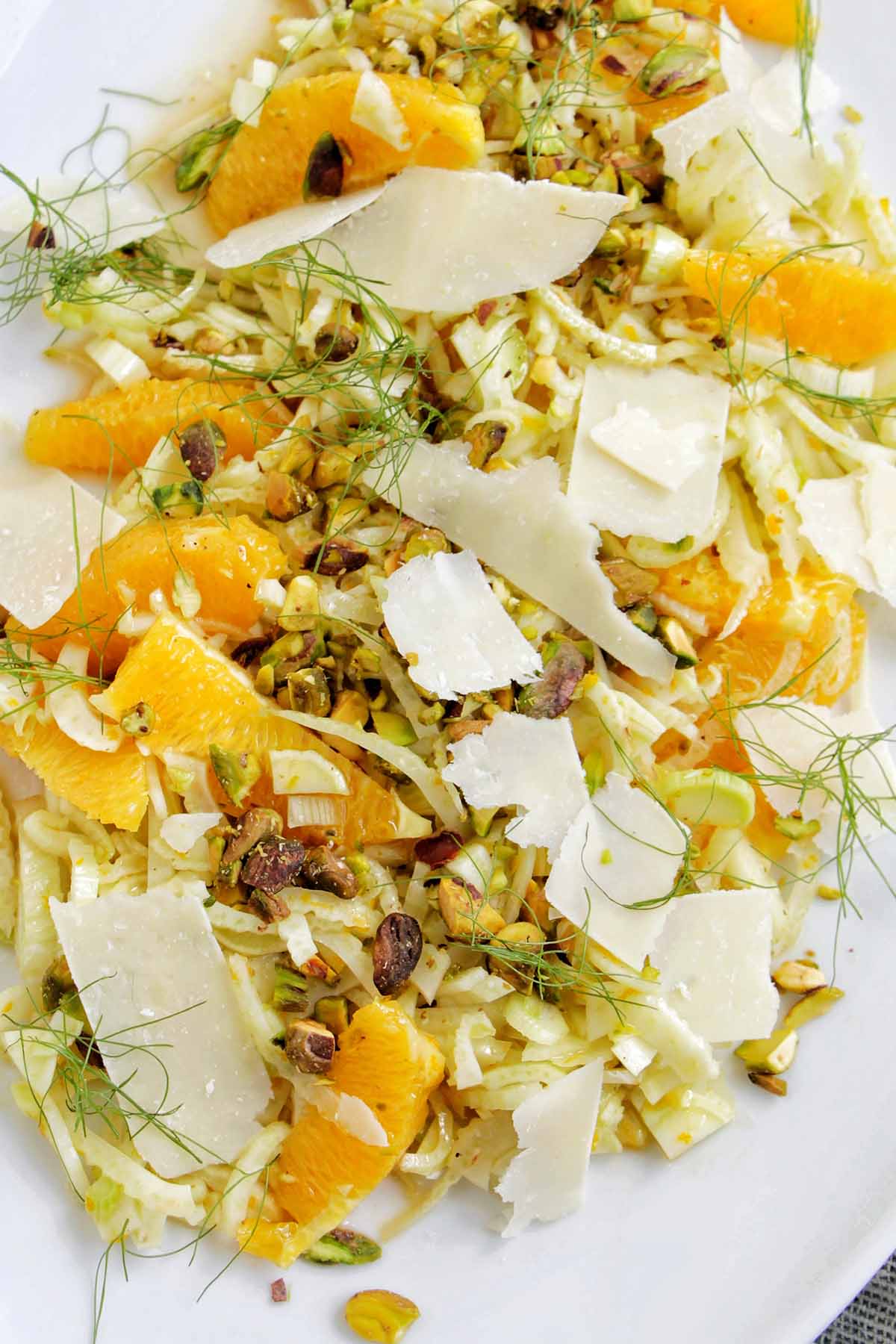 shaved fennel salad topped with orange slices, parmesan, and pistachios.