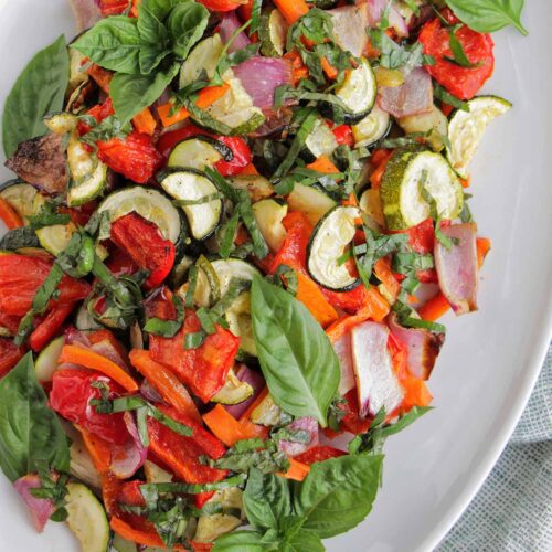 roasted vegetables with herbs on a serving platter.
