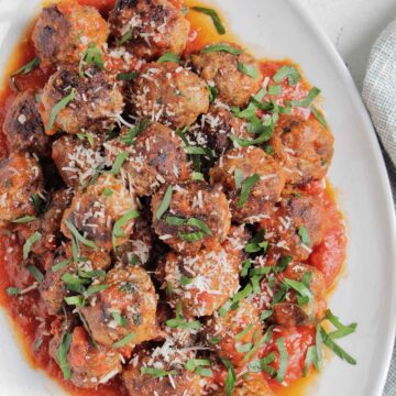 Italian meatballs in sauce topped with parsley.