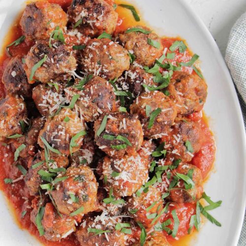 Italian meatballs in sauce topped with parsley.