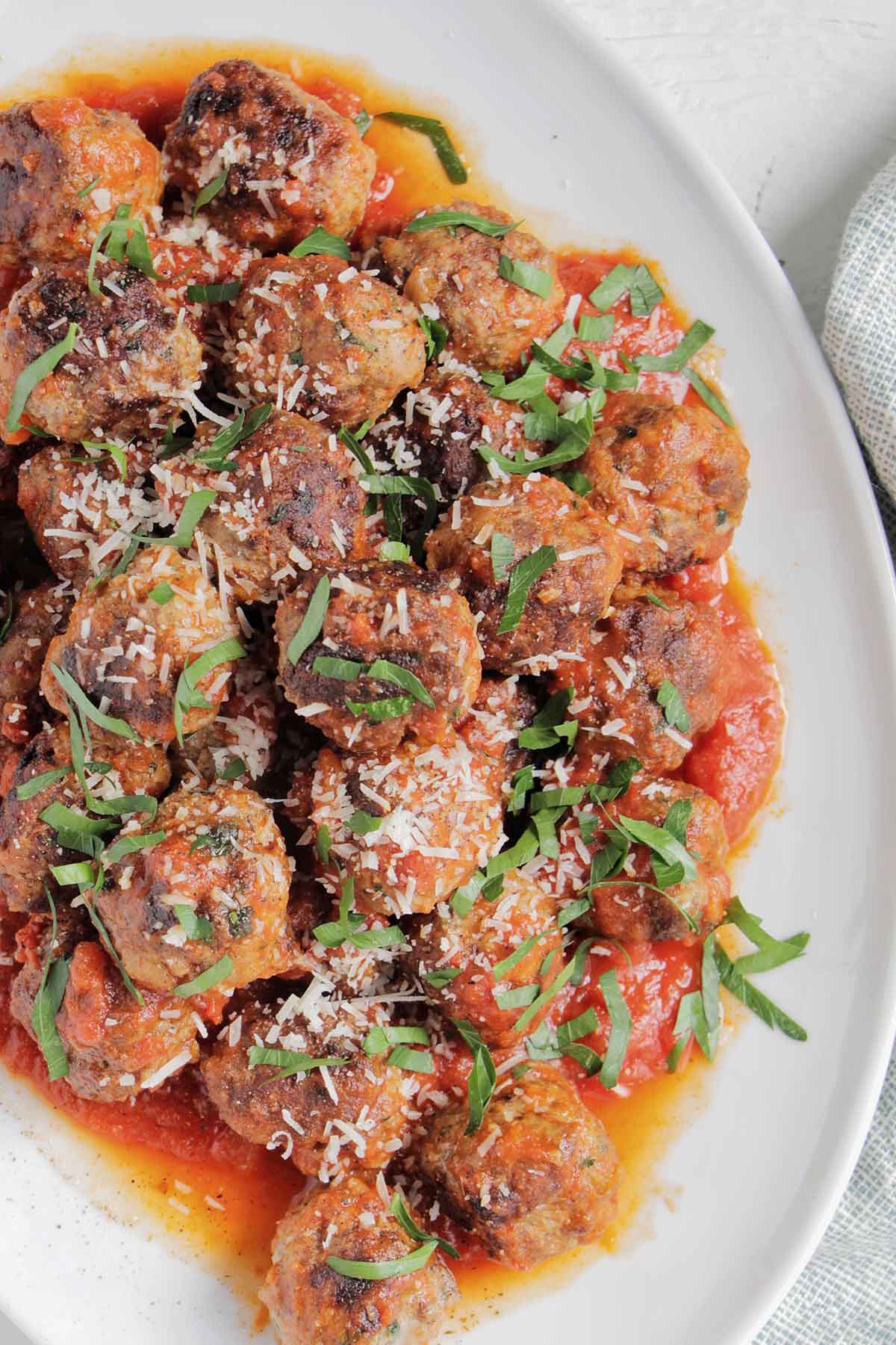 Italian meatballs in sauce topped with parsley.