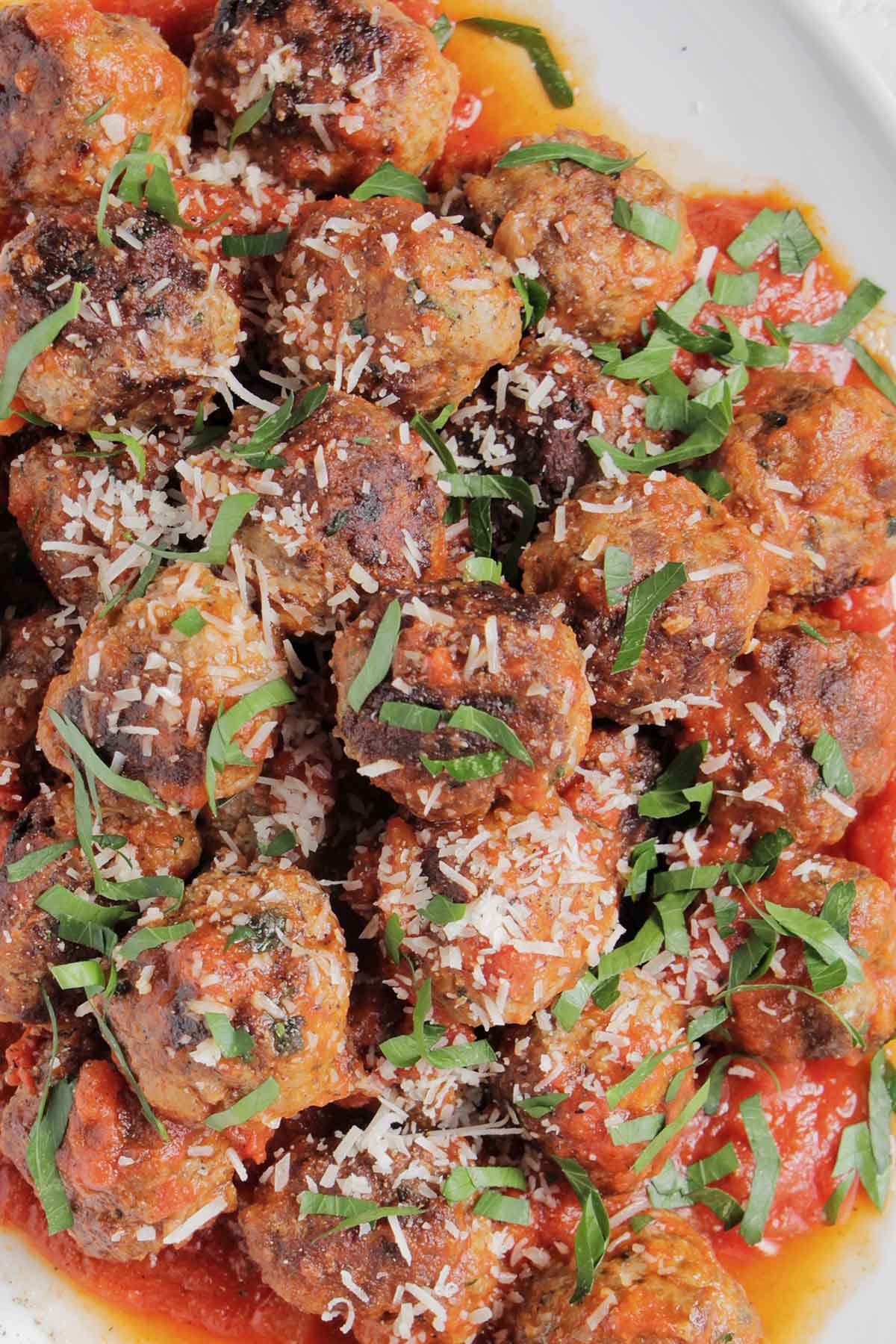 Italian meatballs in sauce topped with parsley.