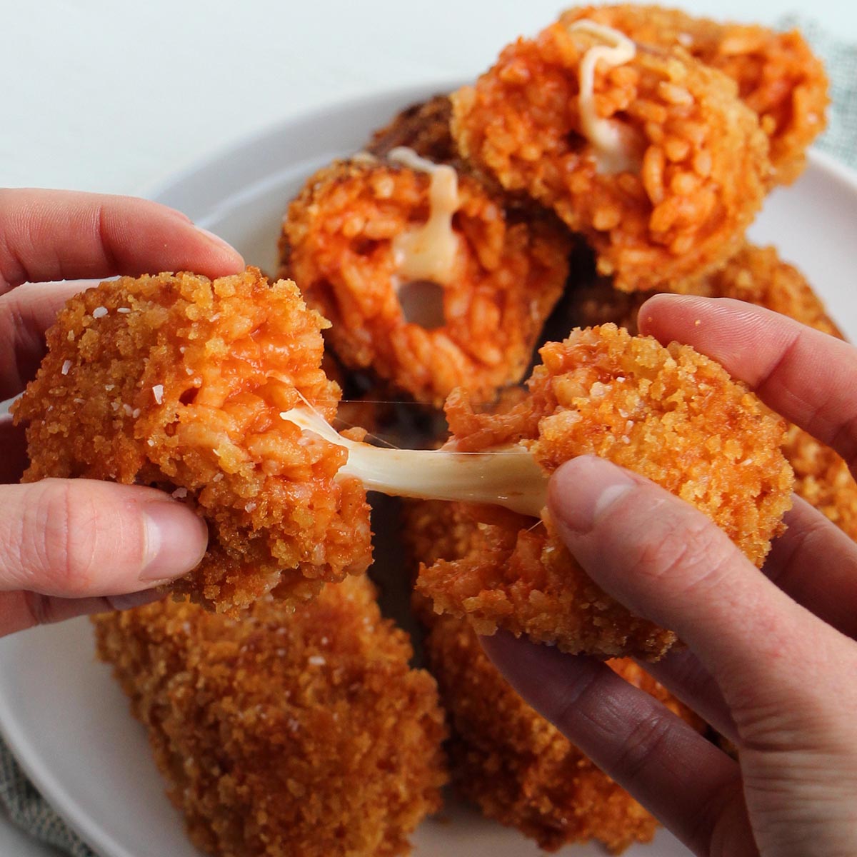 hand pulling apart supplì stuffed with mozzarella cheese.
