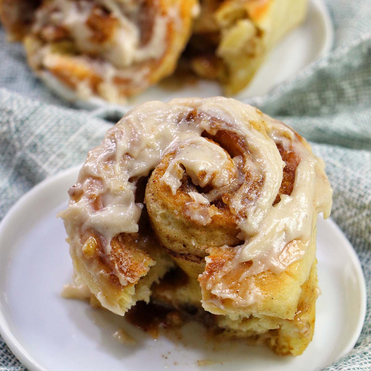 frosted cinnamon roll on a plate.